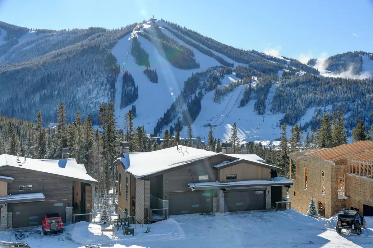 A panoramic view showcases snow-capped mountains, modern chalets, pine trees, and ski slopes, evoking the atmosphere of an alpine adventure destination that is both active and serene.