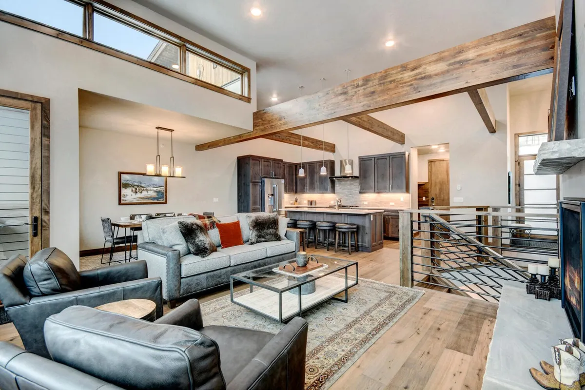 An open-plan interior revealing the kitchen island, dining area, and a cozy living space—framed by large windows that let in ample natural light. The setting is perfect for entertaining, relaxing, and family gatherings, seamlessly connecting cooking, dining, and lounging areas.